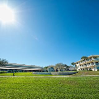 A sunny day on a spacious campus with modern buildings and a clear blue sky.