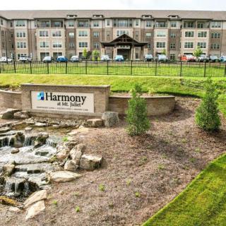 A modern apartment complex with landscaped grounds and a water feature.