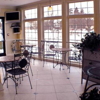 A cozy cafe interior with large windows and empty tables.