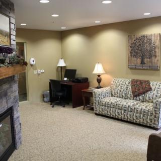 A cozy living room featuring a patterned sofa, a fireplace, and ambient lighting.