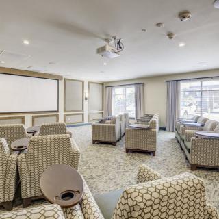 A modern conference room with comfortable seating and a large projector screen.