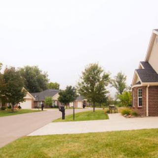 A peaceful suburban neighborhood featuring well-kept houses and lush greenery.