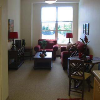 A cozy living room with a sofa, coffee table, and large window.