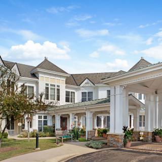 A large suburban residential building with a welcoming entrance and landscaped surroundings.