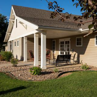 A sunny view of a house with a patio and garden area.