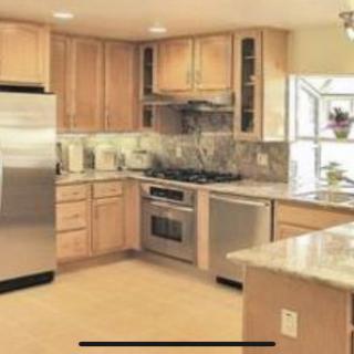 A modern kitchen with stainless steel appliances and wooden cabinets.