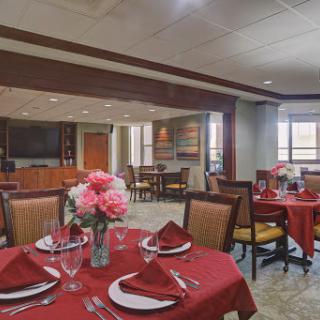 A beautifully arranged dining area with red tablecloths and floral centerpieces, perfect for an inviting meal.