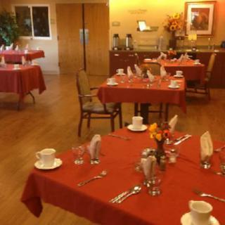 A cozy dining area with red tablecloths and neatly arranged place settings.