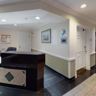 A welcoming office reception area with a front desk and framed artwork on the walls.