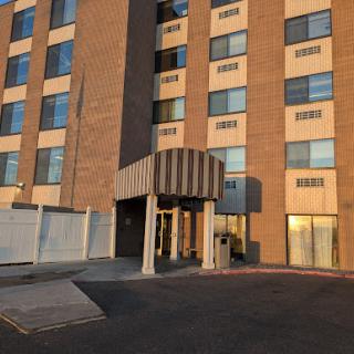 A view of the entrance to a modern brick building with large windows.