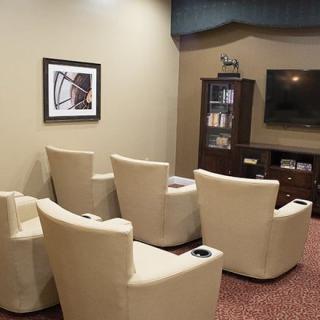 A modern lounge area featuring comfortable seating and a large television.