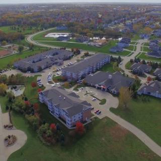Aerial view of a residential complex surrounded by greenery and roads.