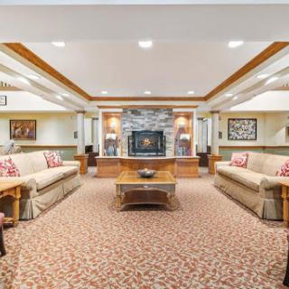 A cozy and inviting living room featuring comfortable seating, a charming fireplace, and decorative artwork.