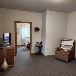 A cozy living room with a recliner, television, and decor.