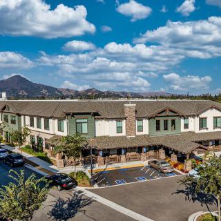A picturesque view of a large building with mountains in the background and a clear sky.