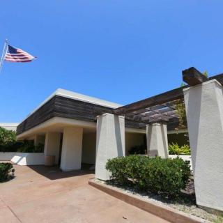 A modern building with an American flag flying under a clear blue sky.