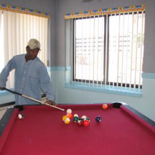 A man skillfully lining up a shot at a pool table.