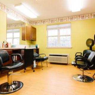 A bright and clean hair salon interior with several styling chairs and mirrors.