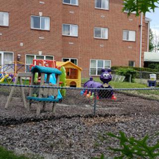 A vibrant playground with colorful equipment located near a residential building.