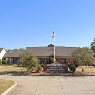 A single-story school building with a flagpole and landscaped surroundings.