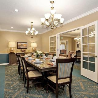 A beautifully set dining room featuring elegant chandeliers and a large dining table with chairs.