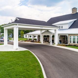 A modern building with a covered entrance and well-maintained driveway.