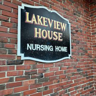 A sign for Lakeview House Nursing Home displayed on a brick wall.