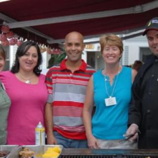 A group of people smiling at a casual outdoor event.