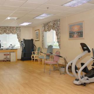 A well-lit gym with exercise equipment and seating area.