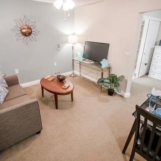 A cozy living room with a sofa, coffee table, television, and stylish decor.