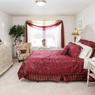 A cozy bedroom with red bedding and elegant decor.