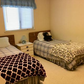 A cozy bedroom with two twin beds and simple decor.