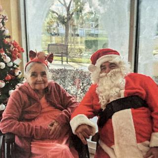 A heartwarming moment capturing the joy of the holiday season with Santa Claus and a cheerful elderly woman.