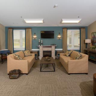 A cozy living room with sofas, a fireplace, and a television.