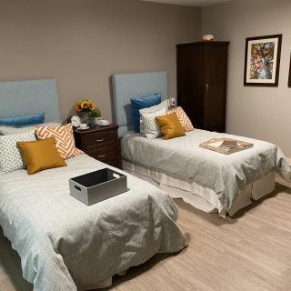 A cozy bedroom featuring twin beds with decorative pillows and a warm interior design.