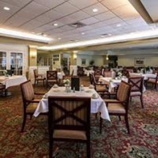 An elegant dining room with neatly arranged tables and chairs, set for a fine dining experience.