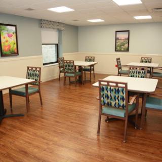 A spacious dining area featuring tables and chairs, complemented by framed artwork on the walls.