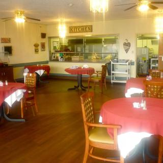 An empty restaurant dining area with tables and chairs neatly arranged.