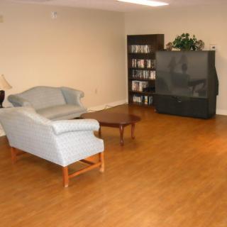 A simple living room setup with a sofa, coffee table, and television.