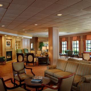 A cozy living room with comfortable seating, a fireplace, and large windows.