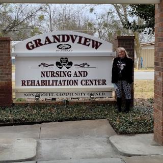 A person stands next to the Grandview Nursing and Rehabilitation Center sign.