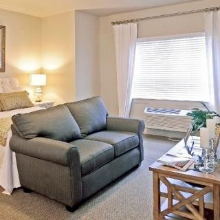 A cozy bedroom with a small living area featuring a sofa and coffee table.