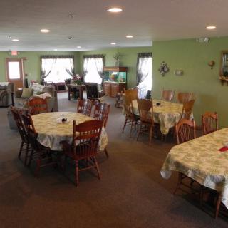 A cozy dining room with several tables and chairs, decorated in a warm and inviting style.