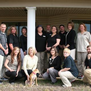 A cheerful team gathers outside for a group photo, showcasing camaraderie and teamwork.