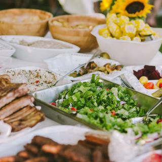 A diverse buffet spread featuring a variety of dishes including salads, meats, and sides.