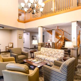 A cozy and inviting lobby space featuring comfortable seating and a stylish chandelier.