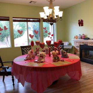 A dining room decorated for Valentine's Day with heart-themed decorations and a festive table setting.