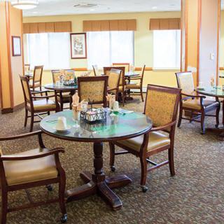 A well-lit dining area with multiple tables and chairs arranged for guests.
