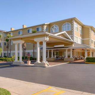 The exterior of a hotel with a covered entrance, set against a clear blue sky.