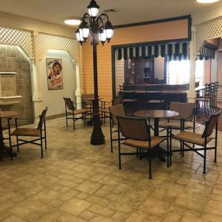 An empty cafe with decorative lighting and arranged tables and chairs.